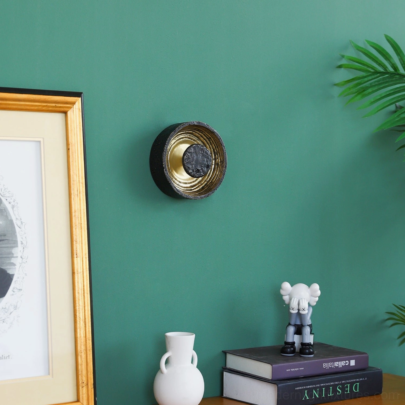 Compact molten metal wall lamp on green wall with framed artwork and decorative figurines, contemporary minimalist black brass design