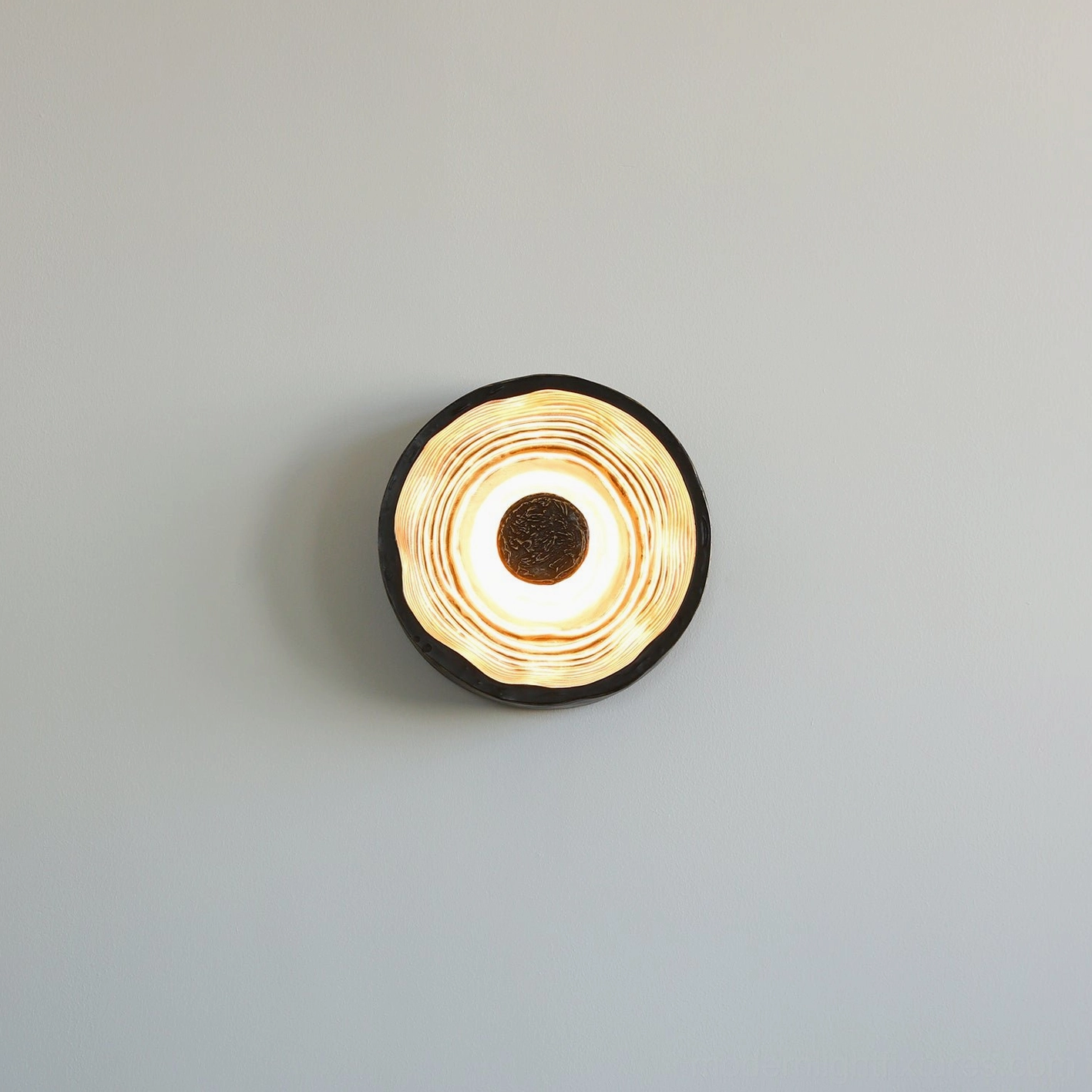Moltena artistic wall lamp mounted above console table, minimalist black metal fixture with gallery-worthy presence