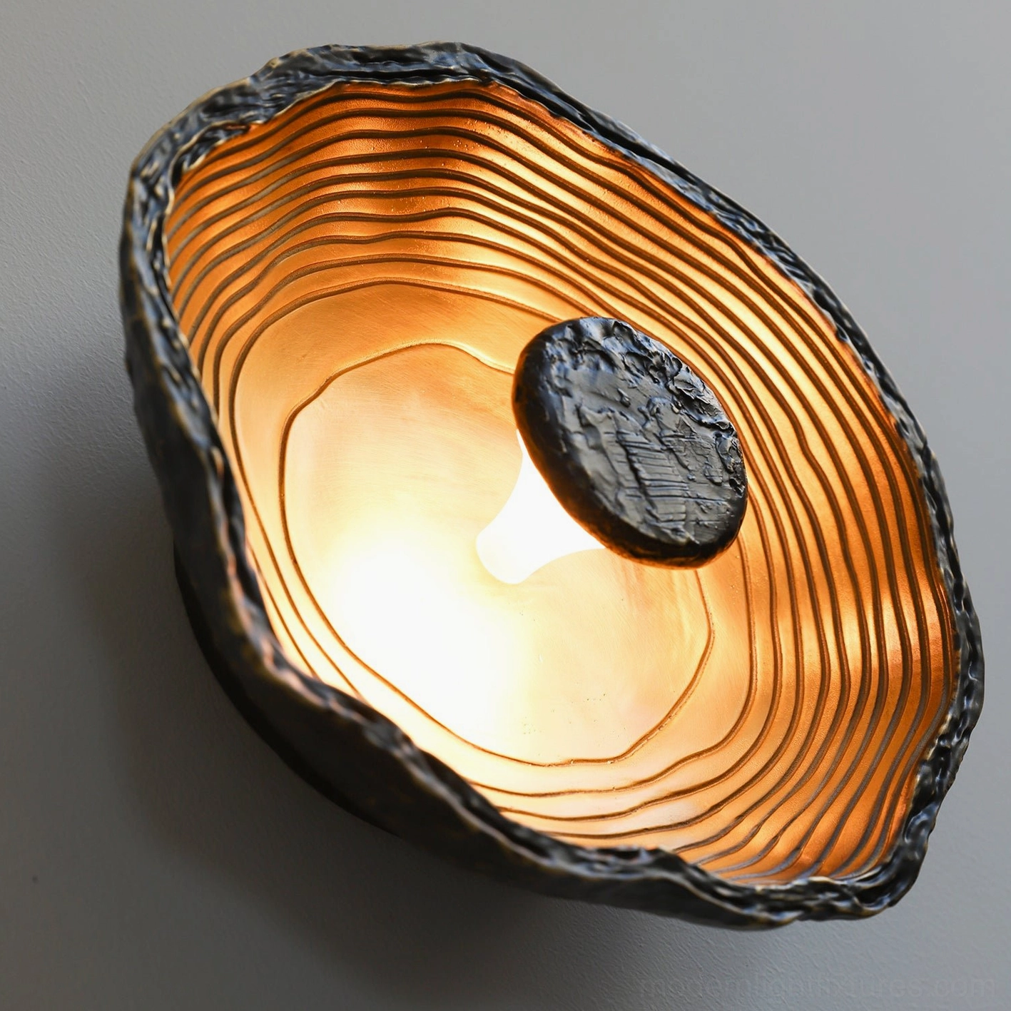Moltena molten metal wall lamp, wabi-sabi inspired design celebrating imperfection and natural textured surfaces