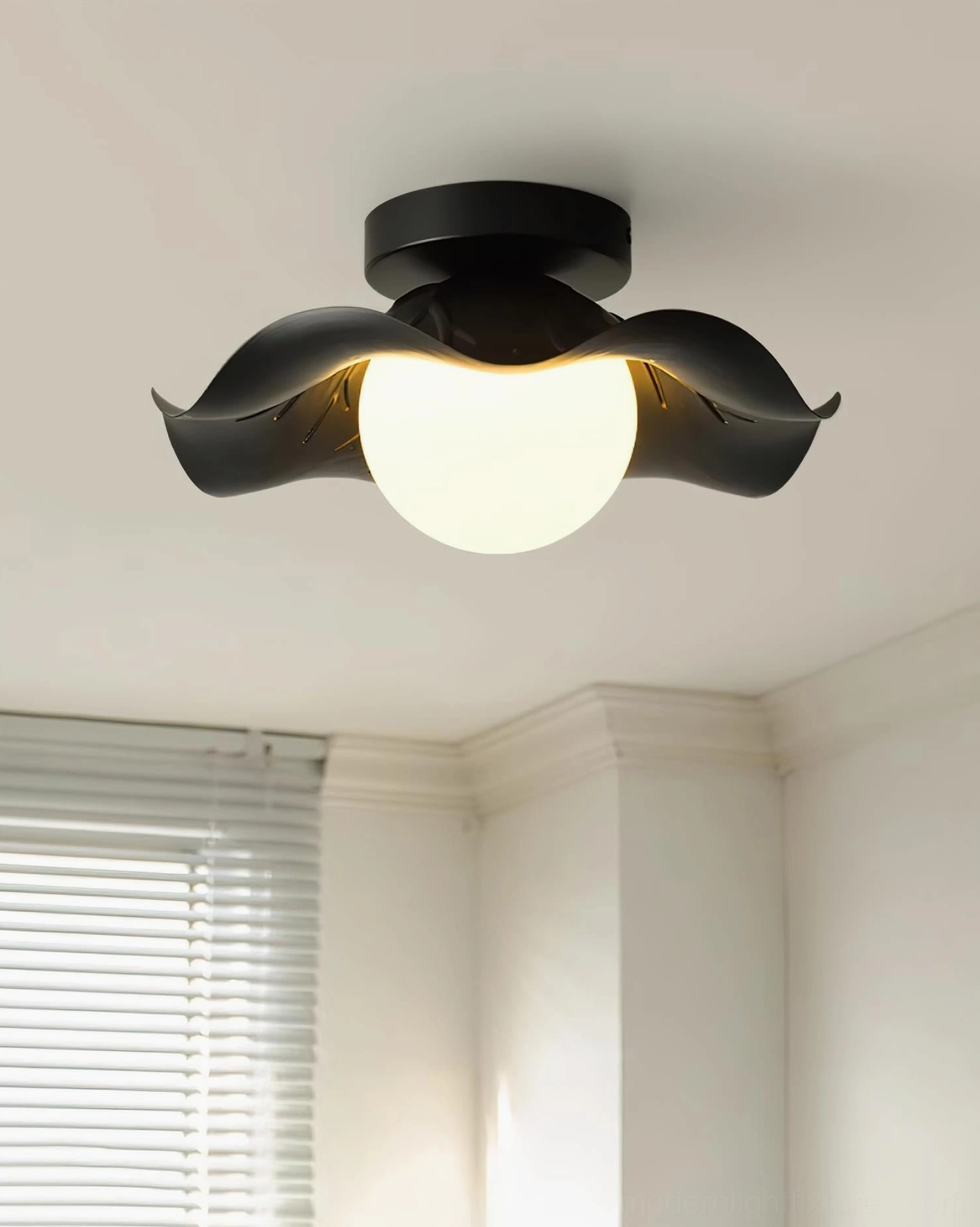 Monae modern ceiling light fixture in bedroom setting with warm glow illuminating black petal-shaped frame