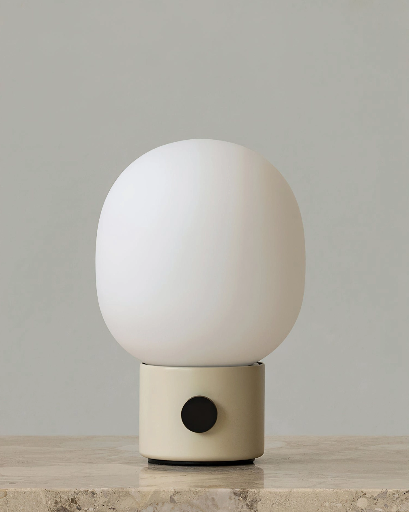 Beige Monolith table lamp sculptural design with frosted glass unlit on stone countertop