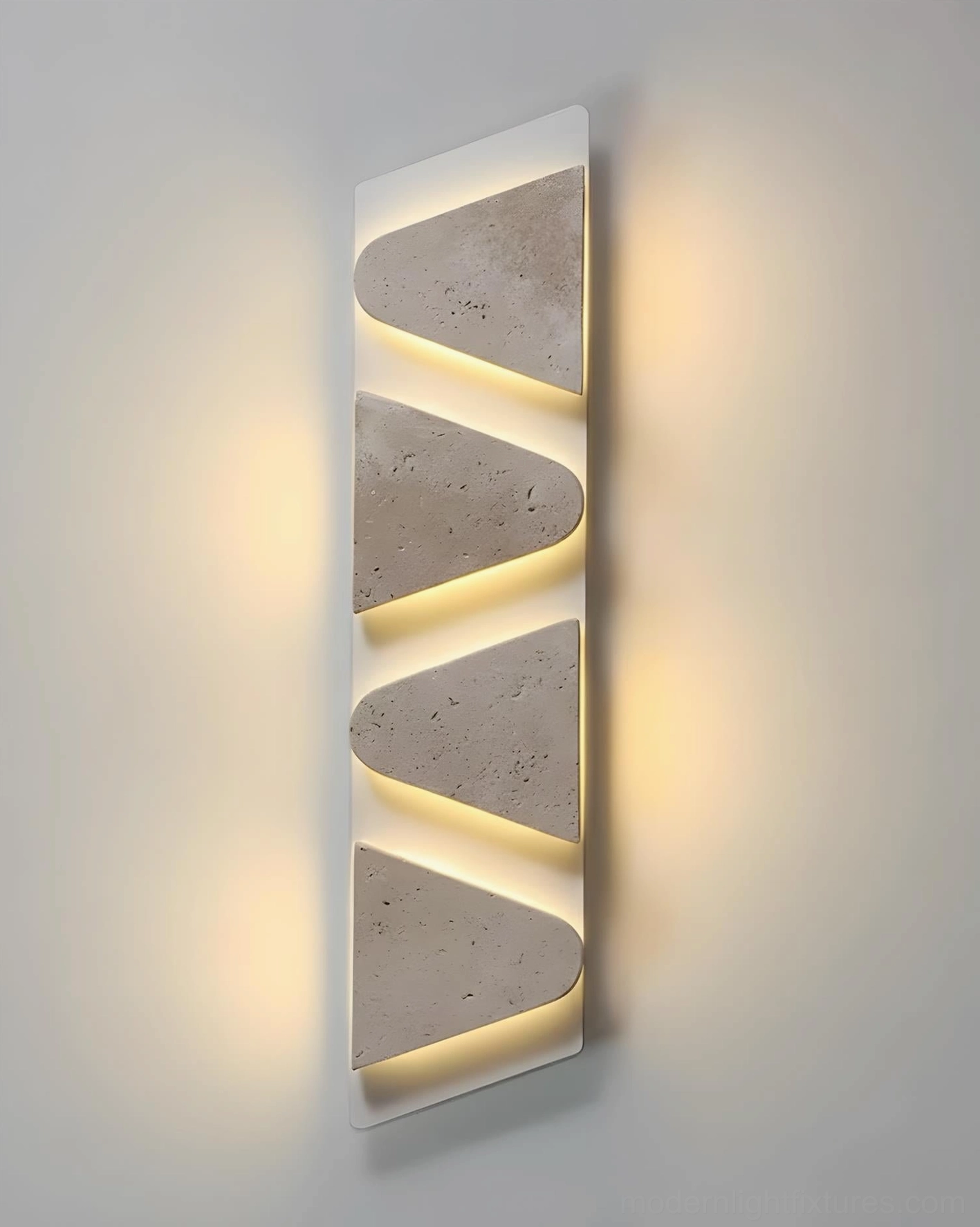 Close-up detail of monolith travertine wall sconce geometric triangular panels with backlight