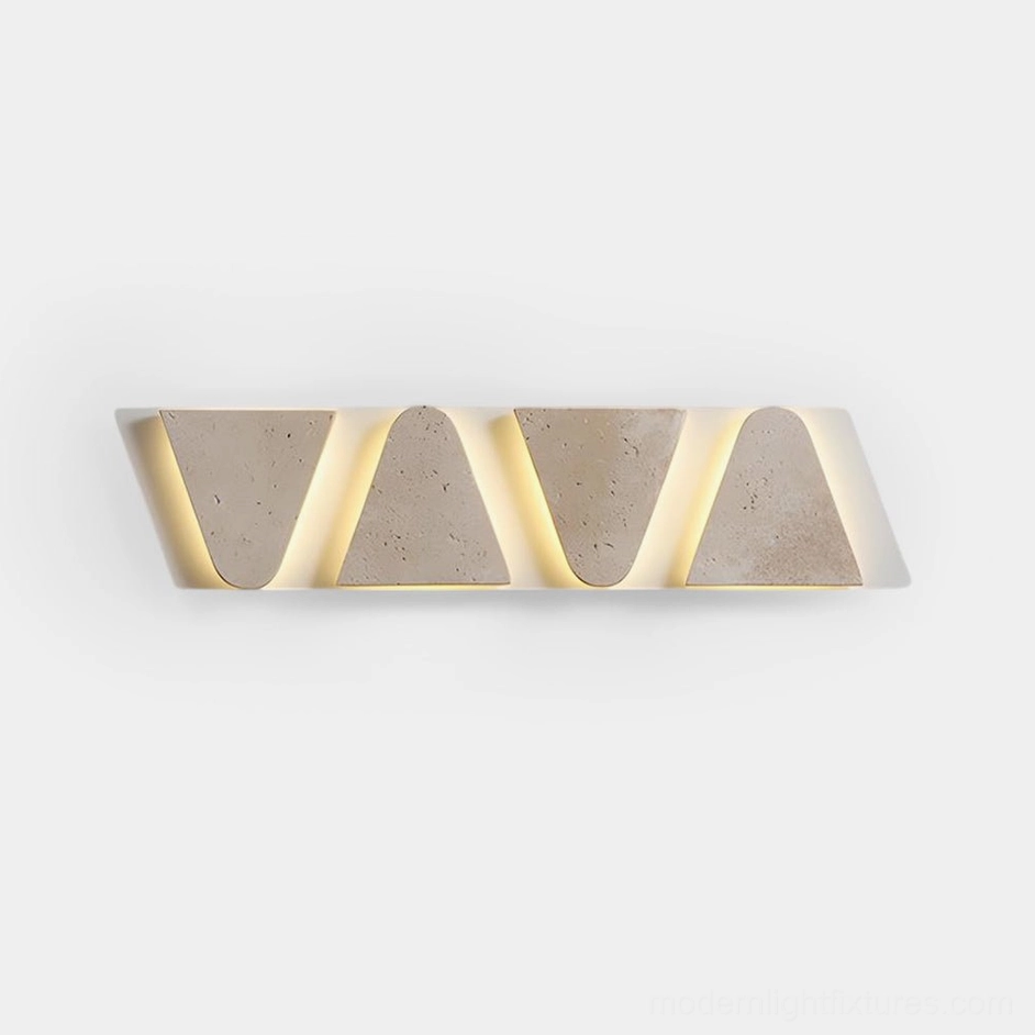 Monolith travertine wall sconce with geometric triangular panels, front view studio product shot