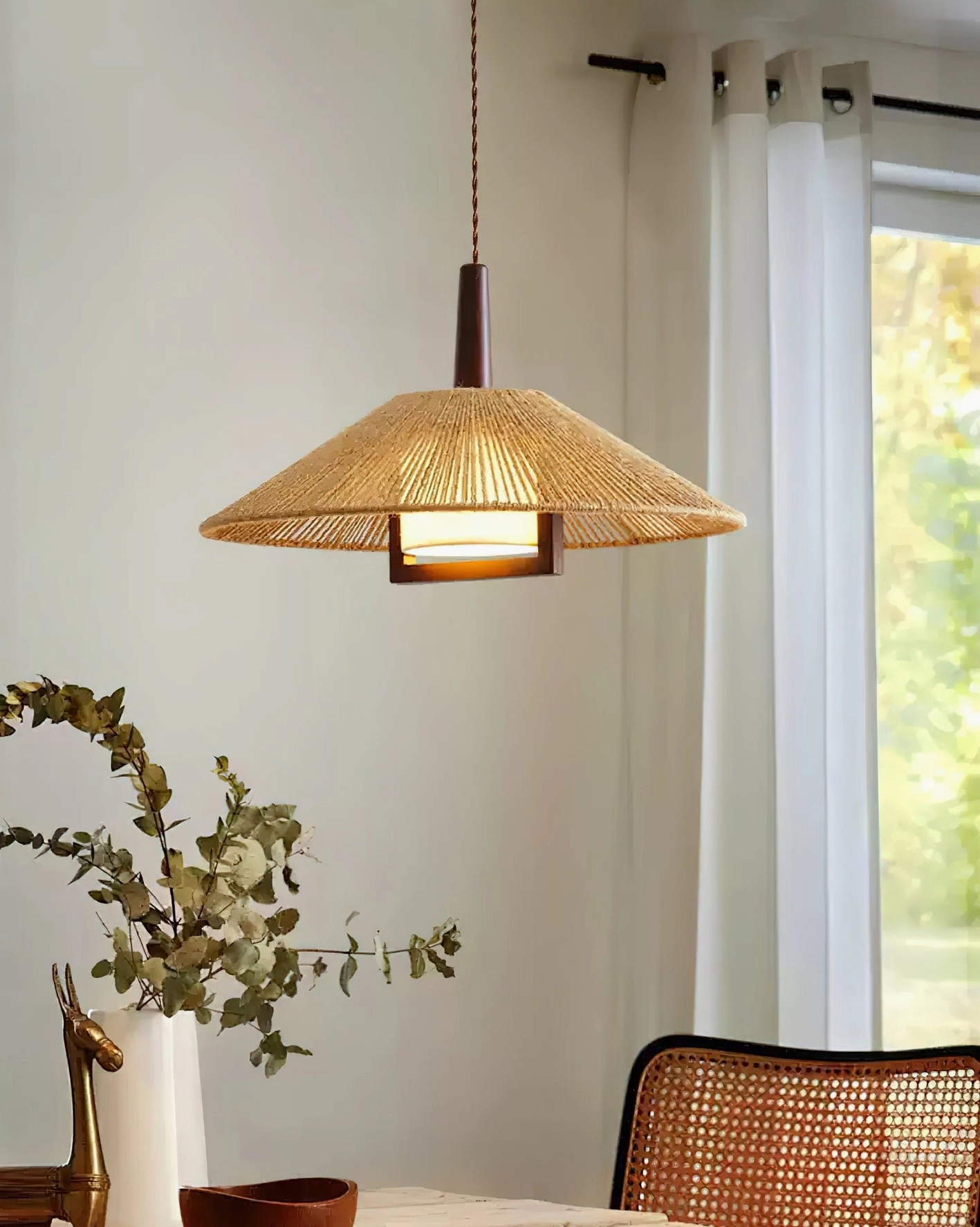 Mons artisanal rattan pendant light hanging in dining area with woven chair and natural decor