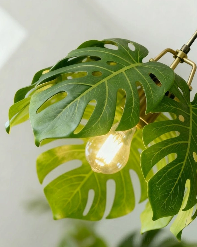 Monstera leaf pendant light illuminated casting dramatic botanical shadow patterns on ceiling and walls
