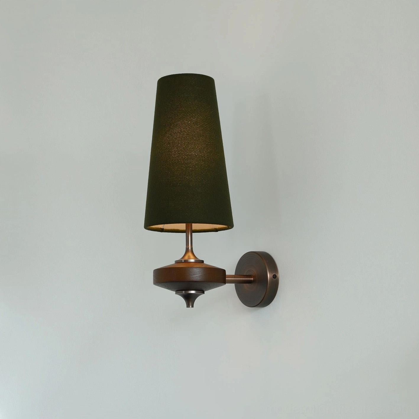 Montera wall sconce close-up detail showing emerald green fabric shade quality and metal base construction