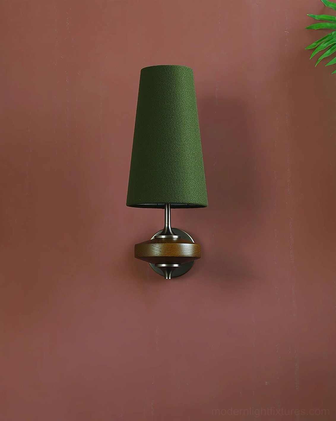 Montera contemporary wall sconce with emerald green conical shade and dark bronze base on terracotta colored wall
