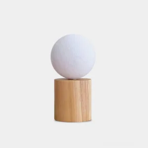 Moon Glow wooden table lamp with crescent moon-shaped shade and natural light wood base, front studio view on white background