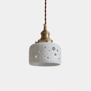 Moonveil ceramic cutout pendant light with circular and floral perforated shade, brass hardware, and twisted cord - front overhead studio view