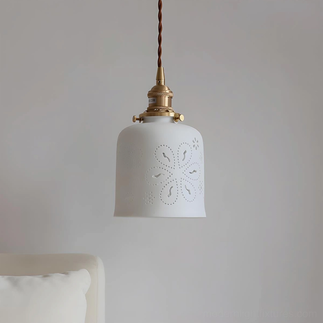 Modern ceramic Moonveil cutout pendant with floral embossed shade and brass metal socket - flat lay styling