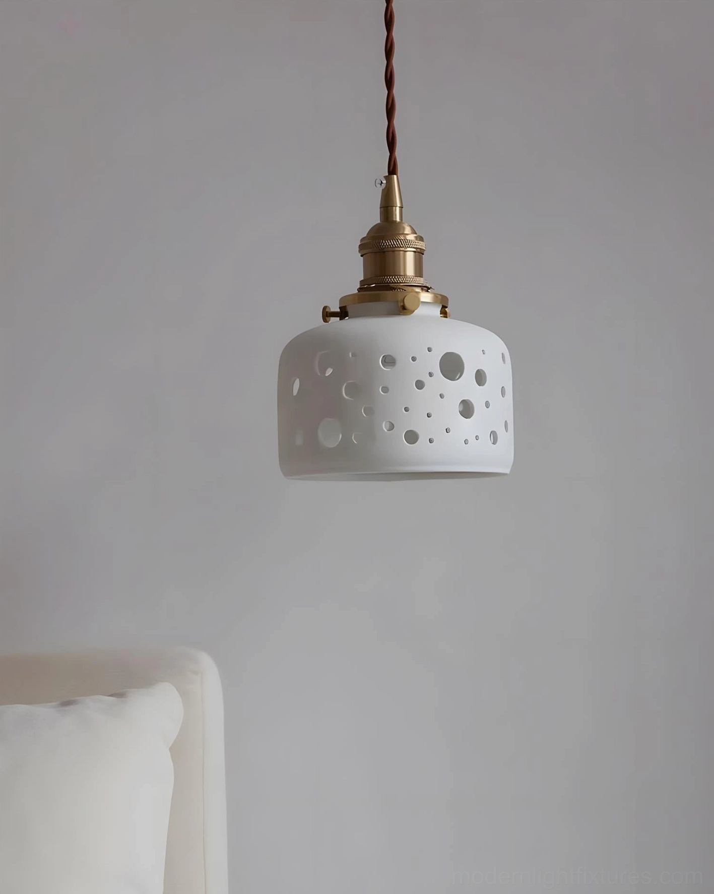 Moonveil ceramic cutout pendant lamp with brass hardware and vintage twisted cord, showcasing modern minimalist design