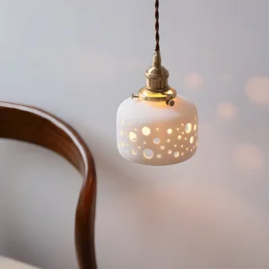 Illuminated Moonveil pendant lamp casting warm ambient light and shadow patterns in minimalist home interior with wooden furniture