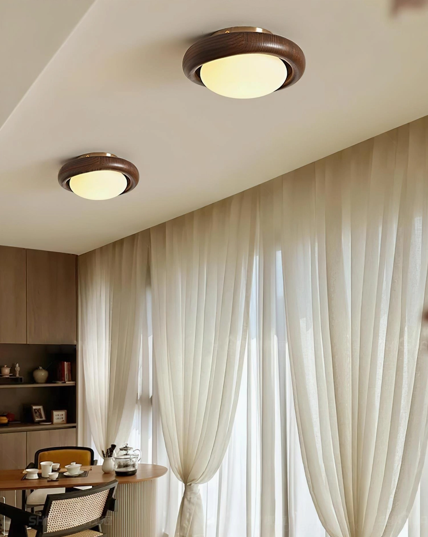 Dual walnut wood ceiling light fixtures installed in dining room creating cozy warm ambient lighting atmosphere