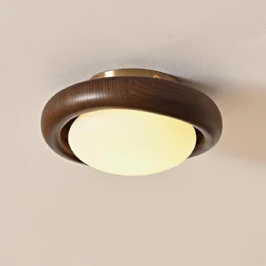 Walnut wood flush mount ceiling lamp installed overhead showing warm glowing frosted dome and dark wood ring trim