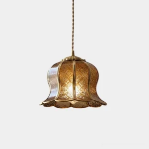 Moroccan brass bell pendant light with embossed floral pattern and amber tone, studio front view