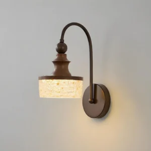 Morven wall sconce illuminated close-up detail, warm white LED glow through textured shade highlighting bronze finish