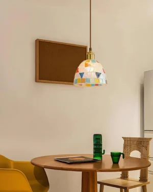 Handcrafted mosaic glass pendant lamp installed in modern dining room creating warm ambient lighting