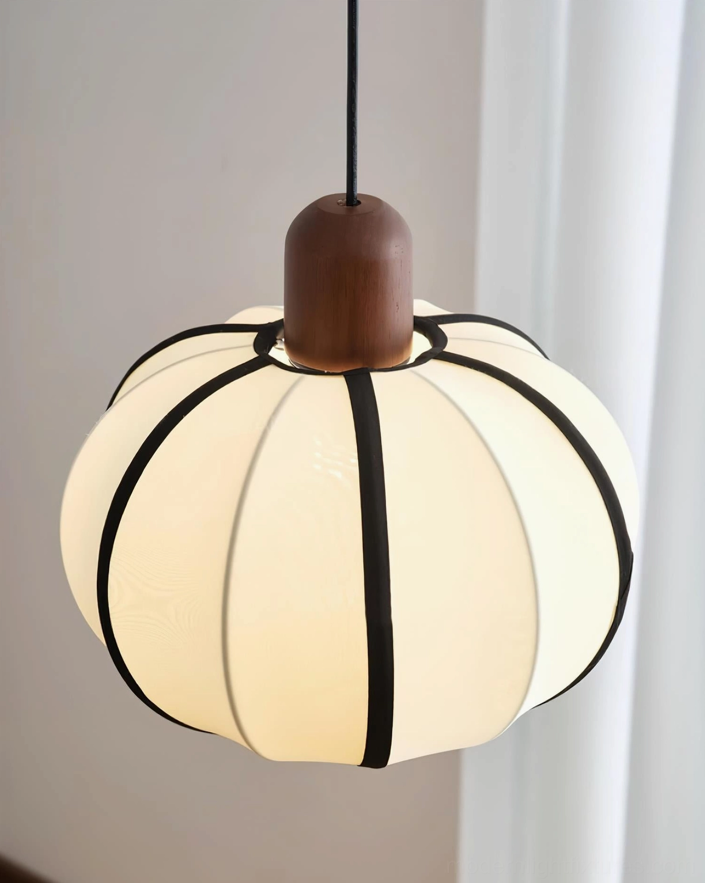 Close-up detail of Mosh pendant light fabric shade - ribbed texture with thick black trim, glowing warm light, contemporary home interior setting