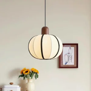 Mosh fabric pendant lamp glowing warmly in minimalist modern home interior with wall art and floral decor - japandi style living space