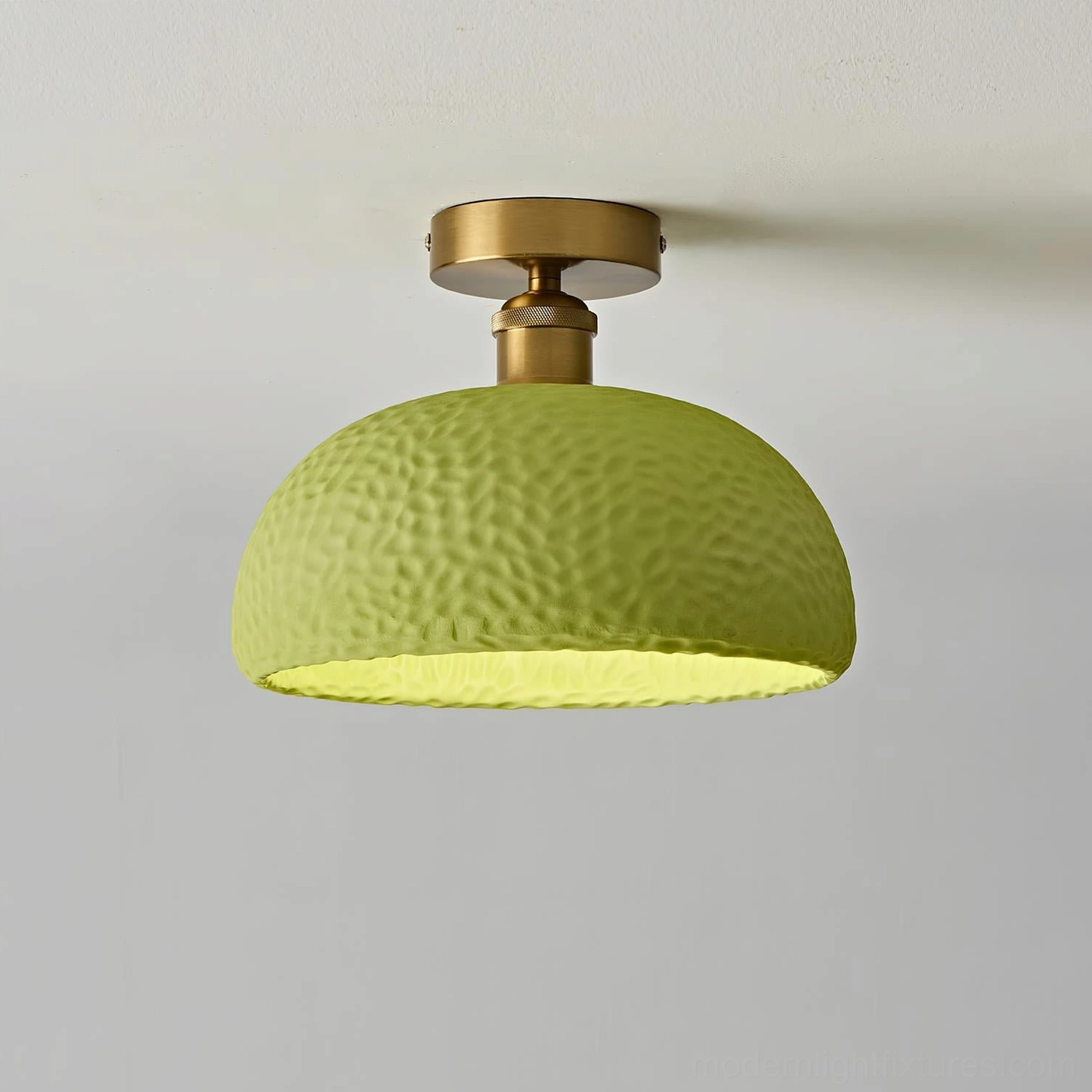 Green semi-flush ceiling fixture with matte textured resin shade emitting warm ambient light - side perspective