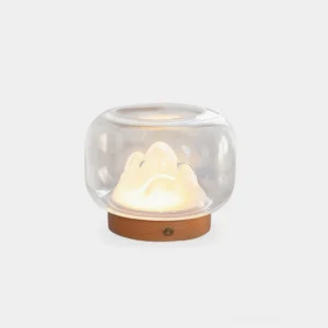 Warm mountain table lamp with clear glass dome and wooden base, front studio view showing illuminated mountain silhouette