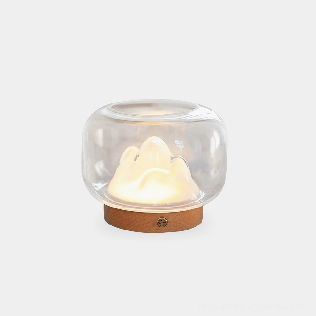Warm mountain table lamp with clear glass dome and wooden base, front studio view showing illuminated mountain silhouette