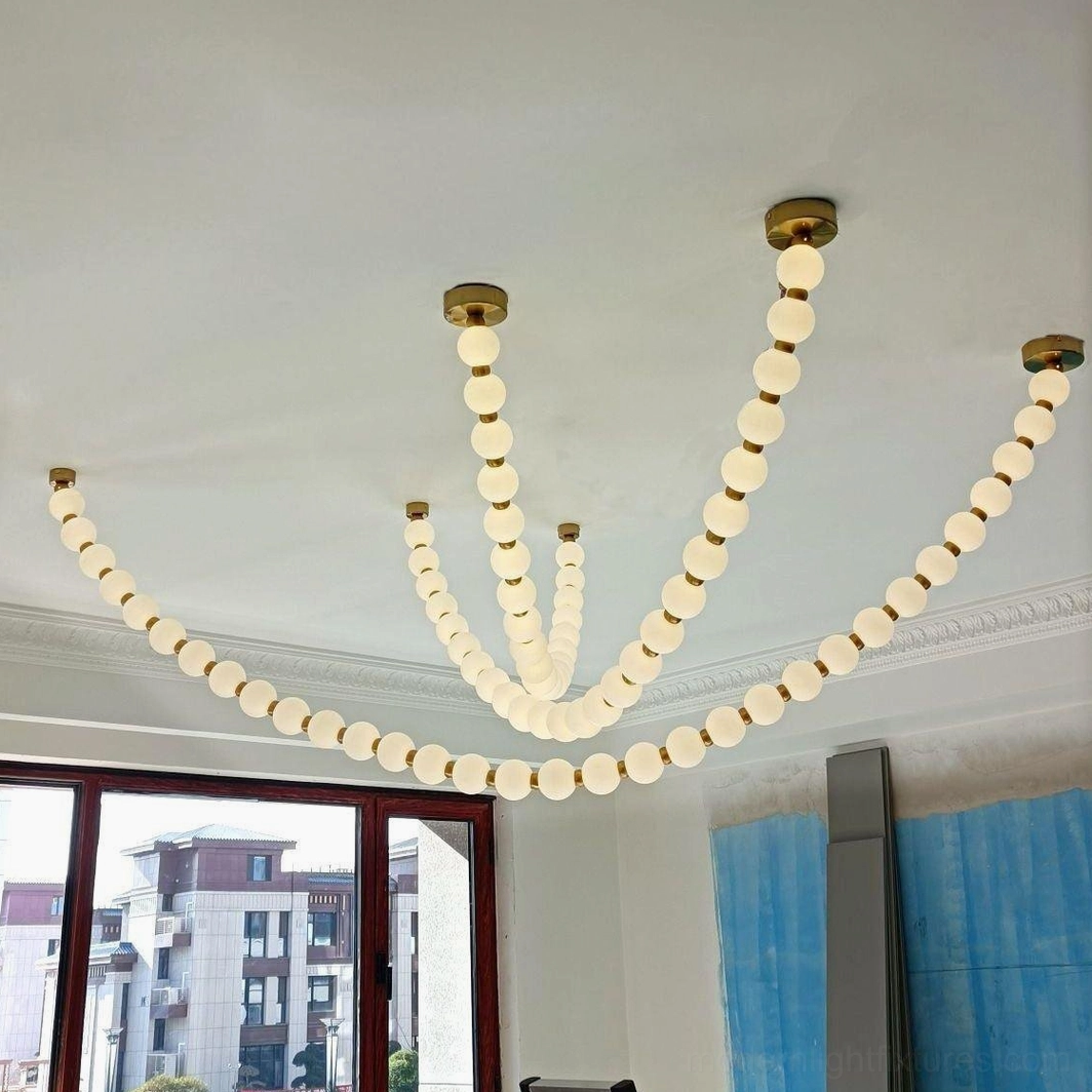 Light luxury multi-arc pearl chandelier in residential space with floor-to-ceiling windows and white frosted orbs