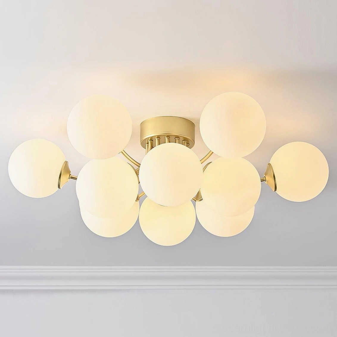 Large multi-ball sputnik ceiling light detail shot displaying brass gold arms and frosted spherical glass shades