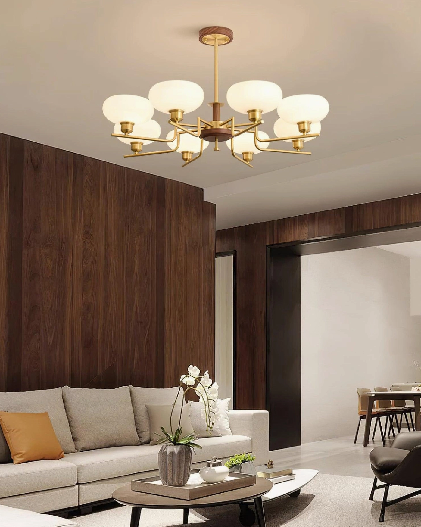 Contemporary 8-head multi-pendant glass chandelier in wood-paneled living and dining area with off-white furniture warm lighting