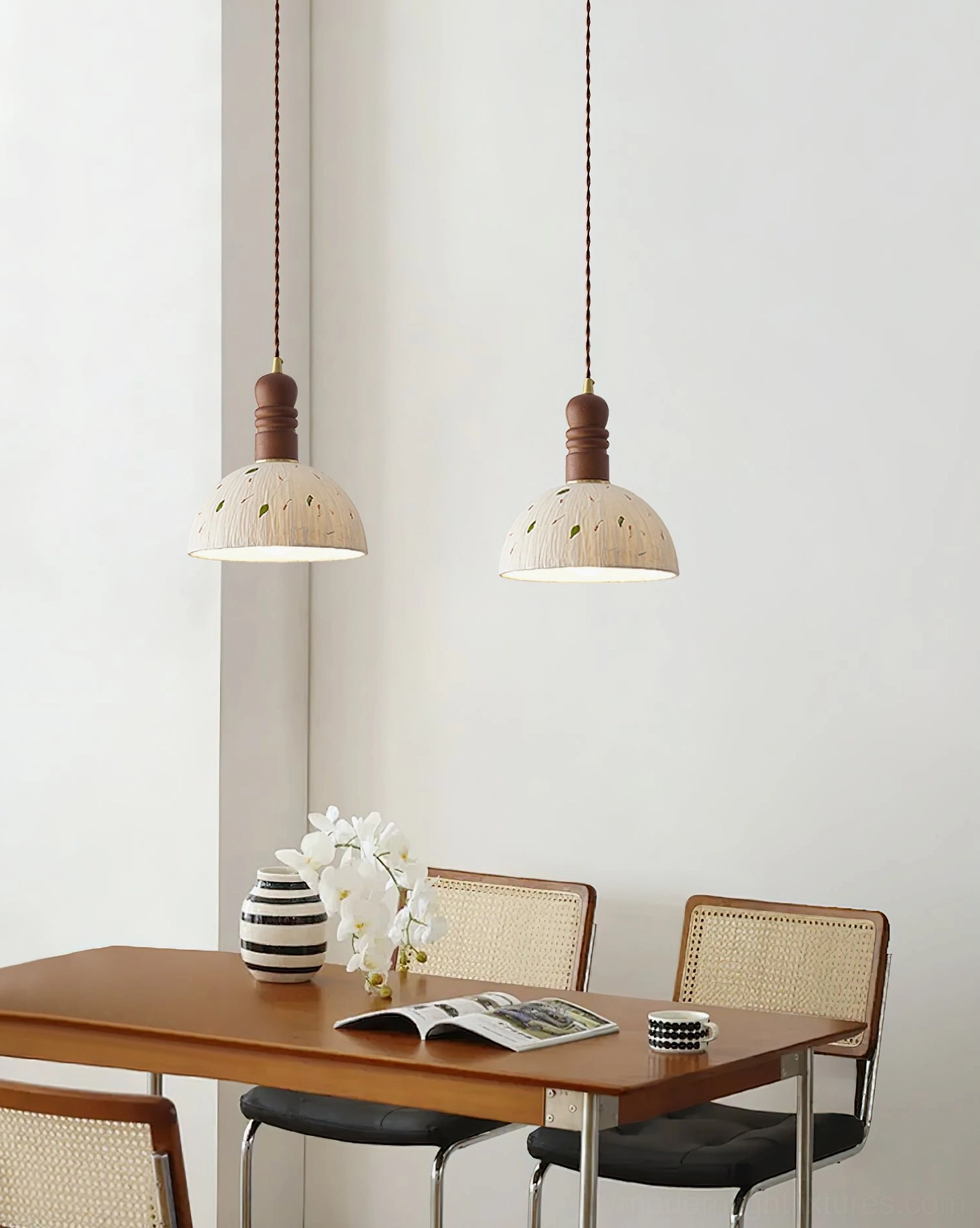 Pair of matching off-white speckled dome pendant lamps suspended over modern wooden dining table