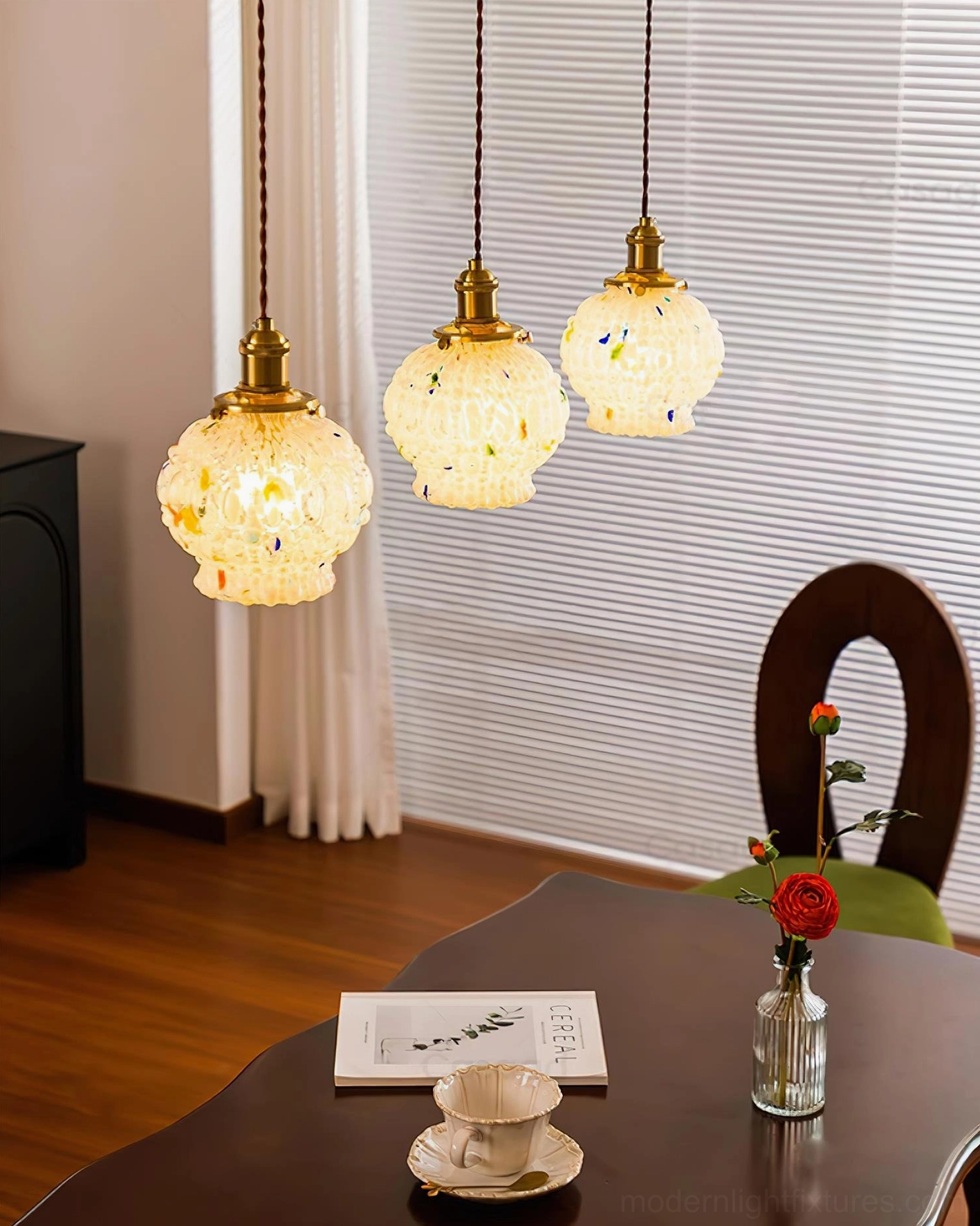 Three-piece hand-blown glass bubble pendant light set, matching brass fixtures, vintage dining room decor with table setting