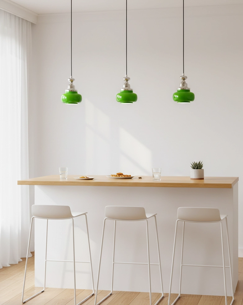 Set of three jade green pendant lights hanging above modern kitchen bar counter