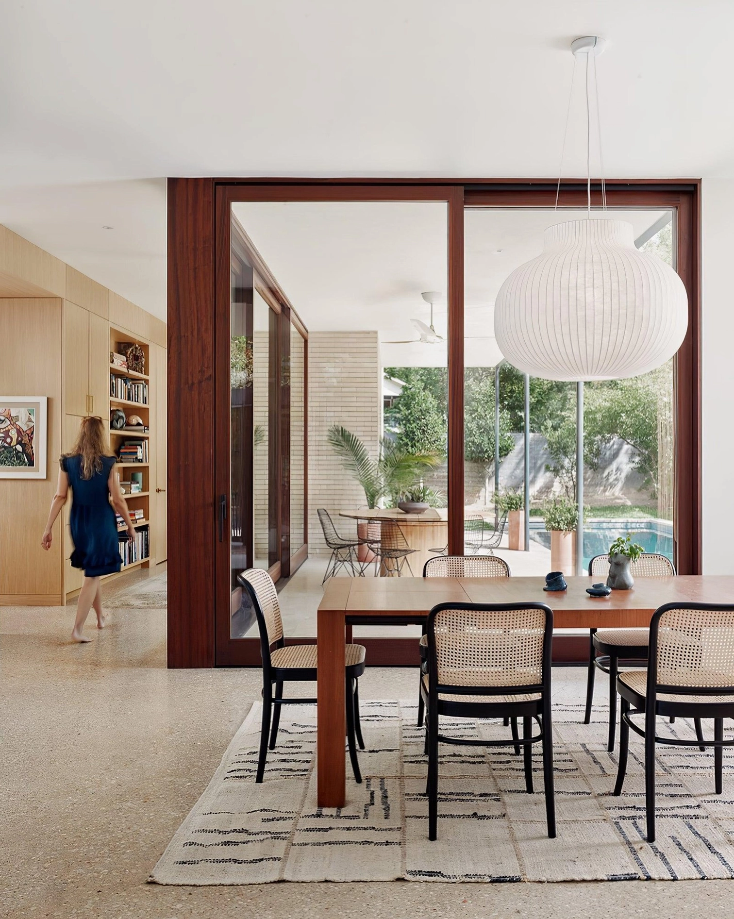 Multiple modern cocoon pendant lights at varying heights creating layered lighting arrangement