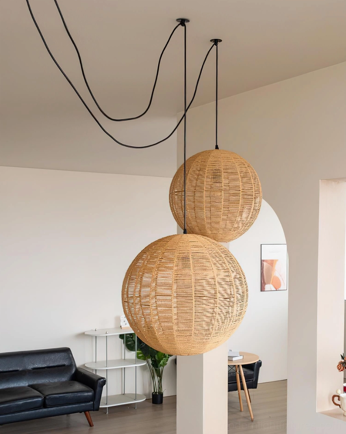 Multiple rattan woven sphere pendant lamps arranged at different heights in contemporary space