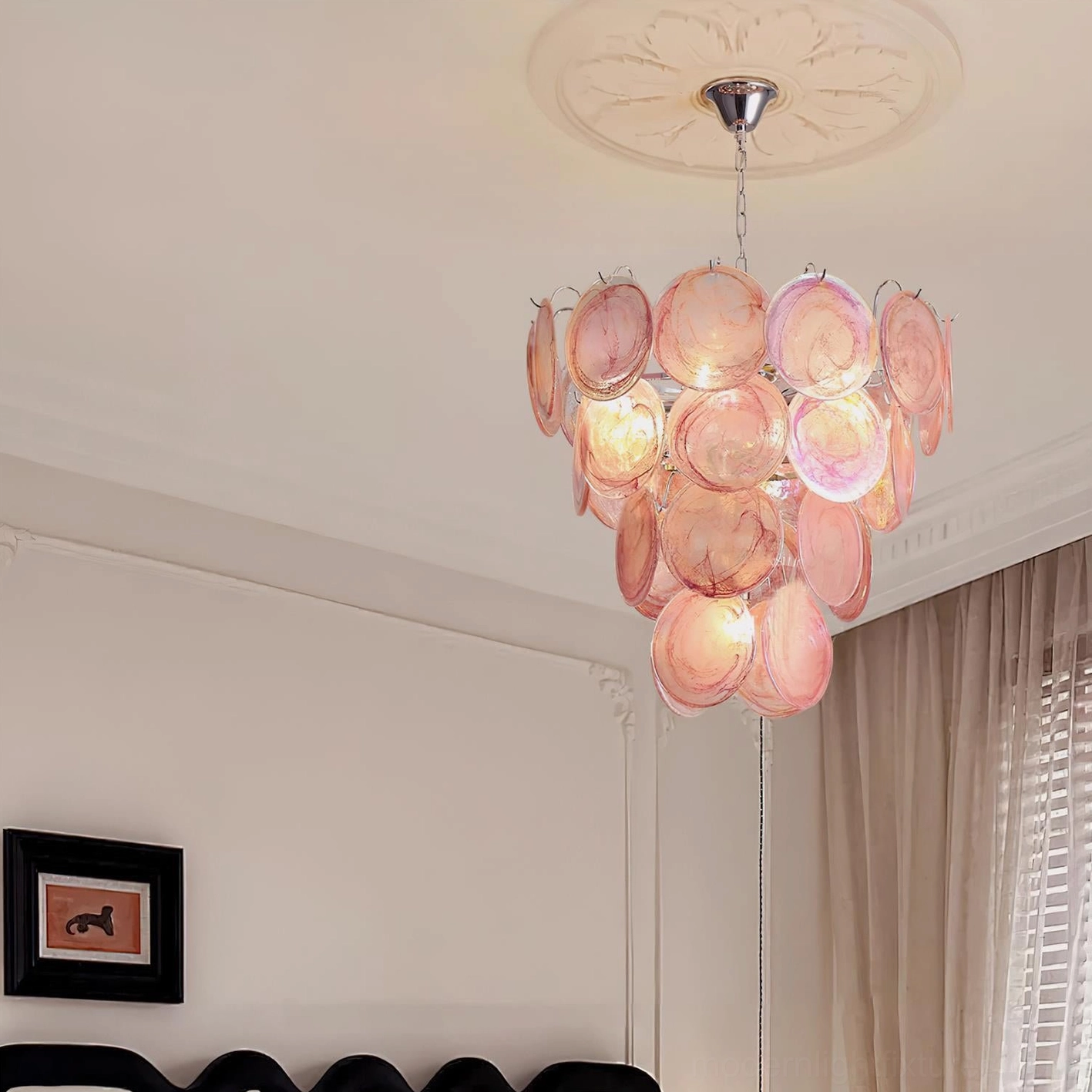 Pink hand-blown glass disc chandelier in bedroom interior with neutral tones and window natural light