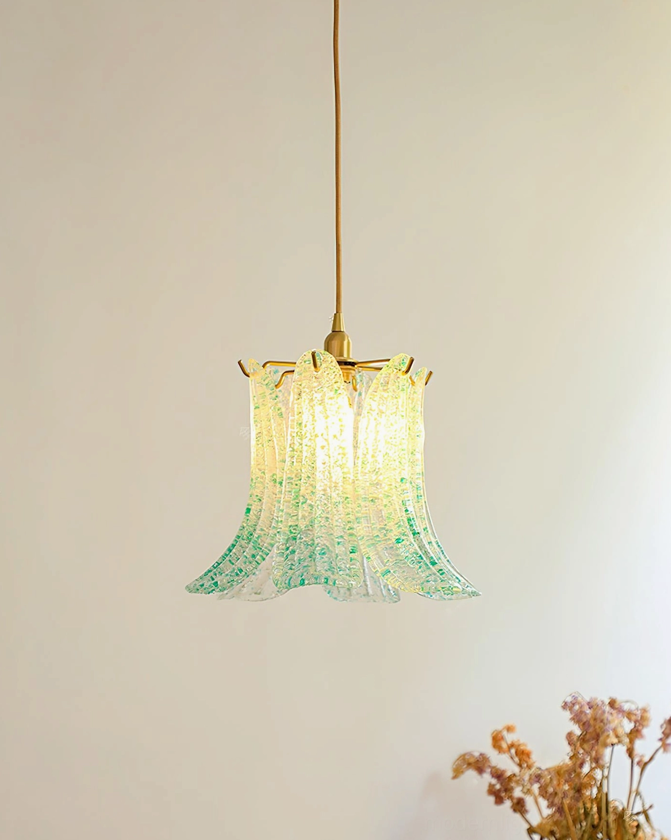 Compact green gradient Murano glass lily pendant light with warm glow, home interior with dried flower arrangement