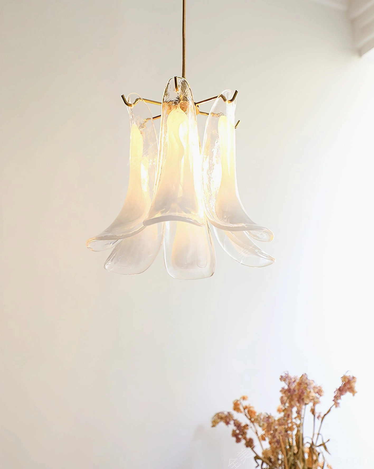 Clear transparent Murano glass pendant lamp glowing with warm light, minimalist home interior backdrop