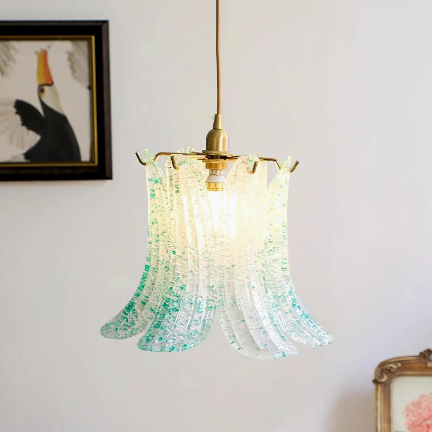 Italian Murano glass pendant light in aqua green with brass fixtures, home interior setting with white wall