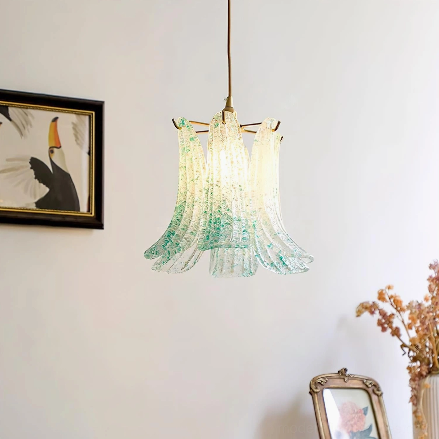 Green speckled Murano glass pendant lamp with brass hardware and illuminated bulb, decorated home interior with wall art