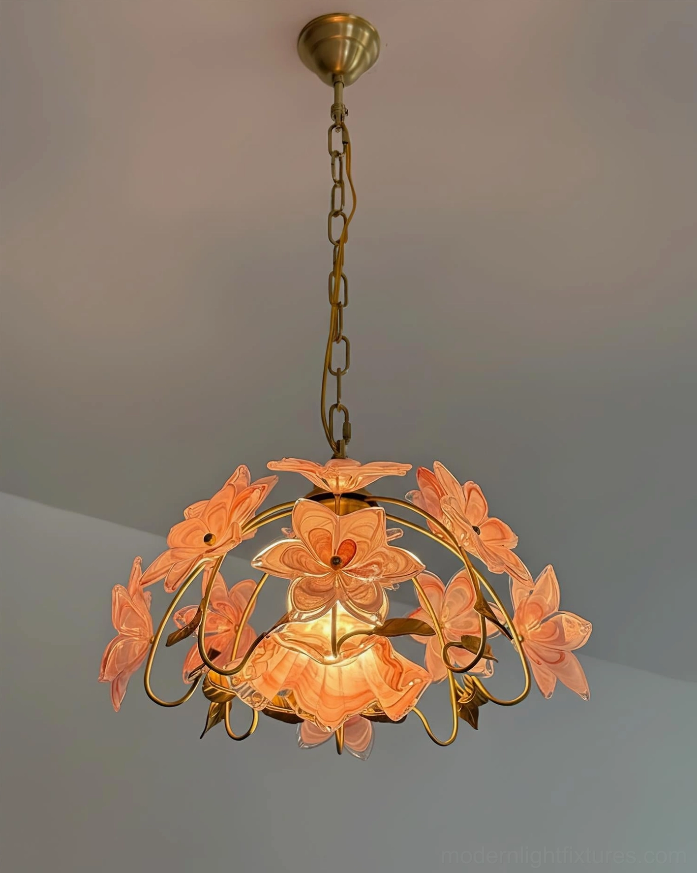 Close-up detail of Blossira pink Murano-style glass petals arranged around brass frame
