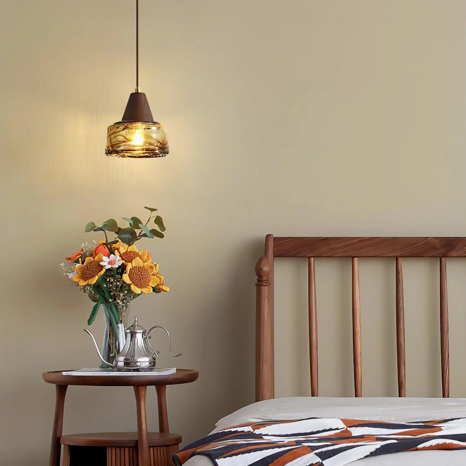 Single Murano amber glass pendant light in cozy bedroom corner with wooden nightstand