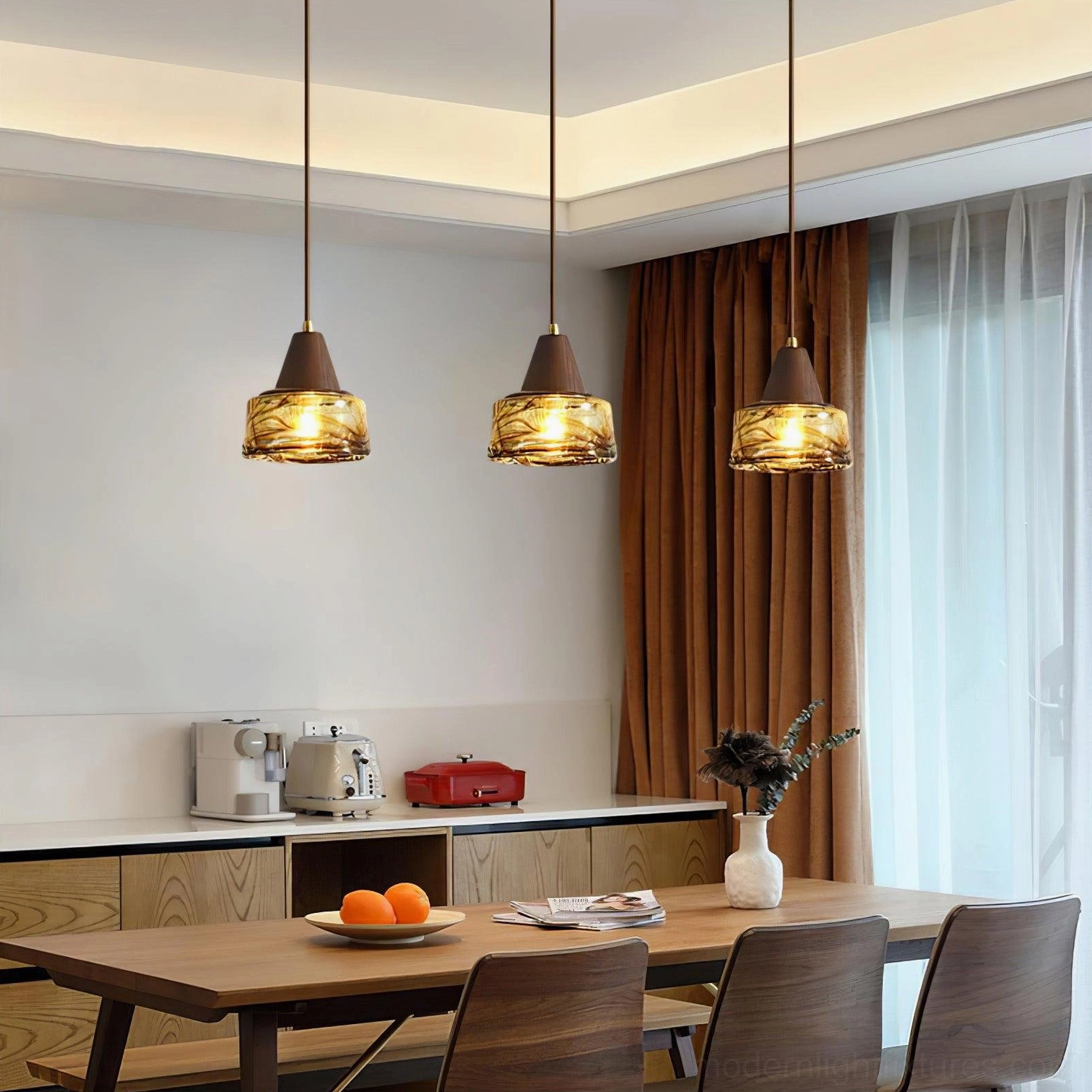 Three-piece Murano amber glass pendant light set installed above modern kitchen island
