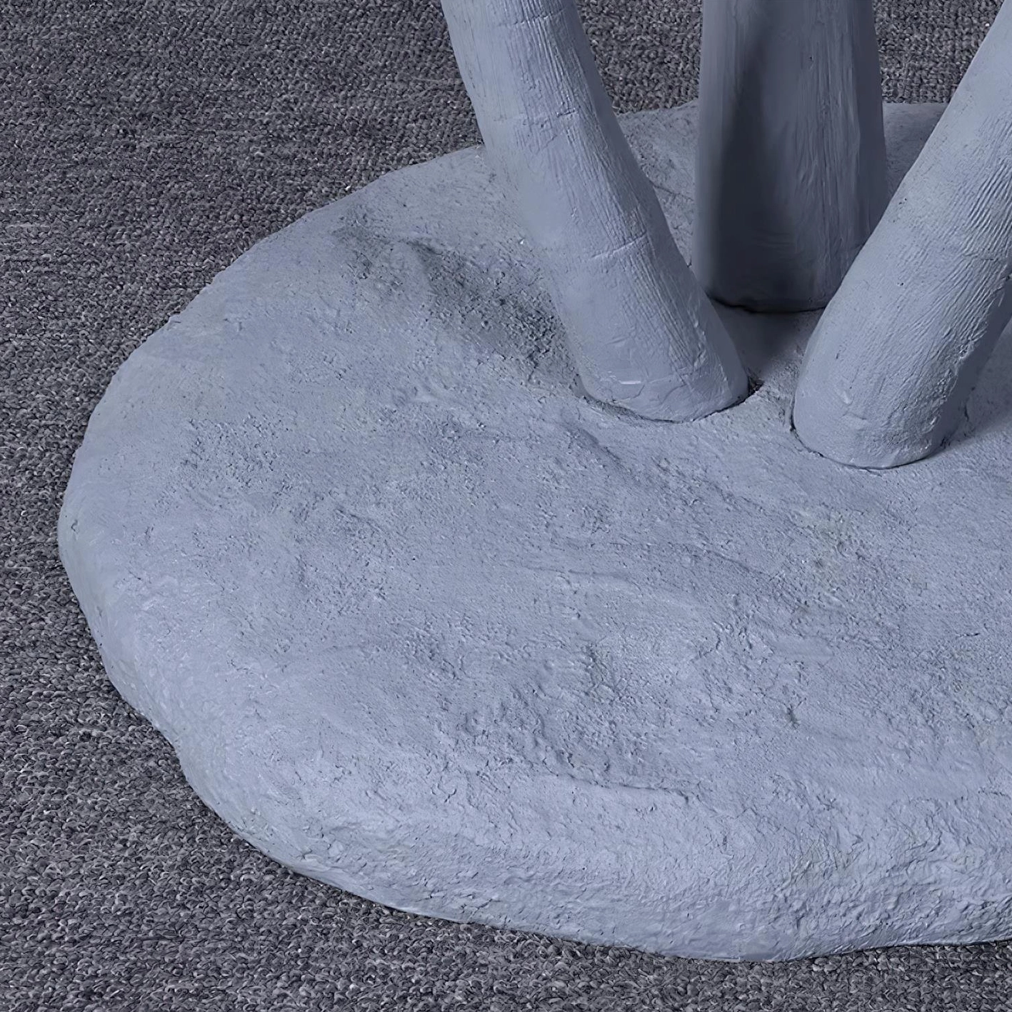 Close-up detail of mushroom lamp base and elongated stem showing matte textured concrete-like finish on carpeted floor