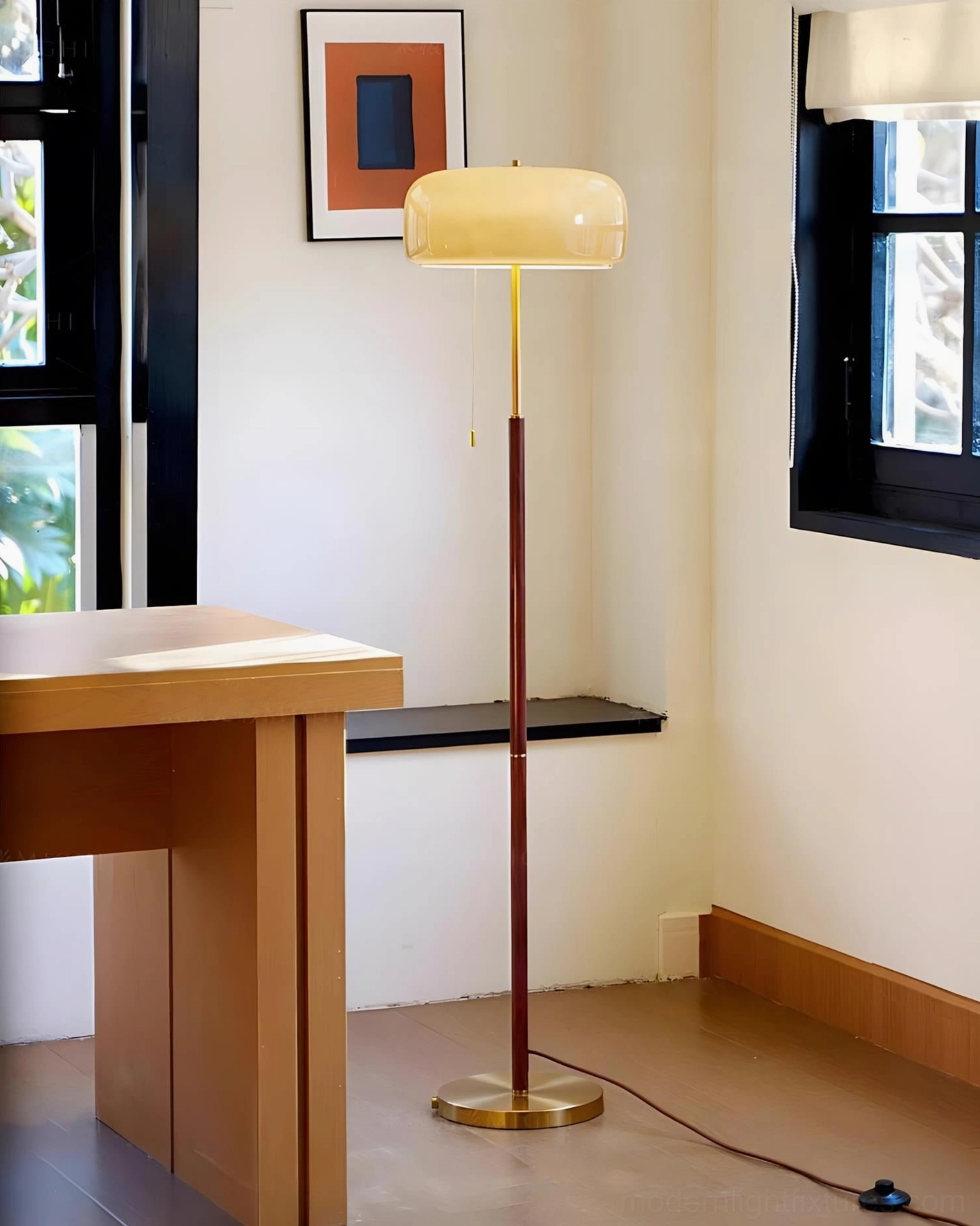 Mushroom floor lamp with beige glass shade in home office setting, brass base and wood pole visible
