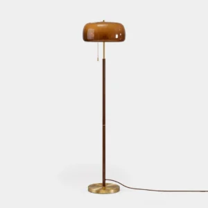 Mushroom floor lamp with brass base and walnut wood stem against white studio background, mid-century modern design