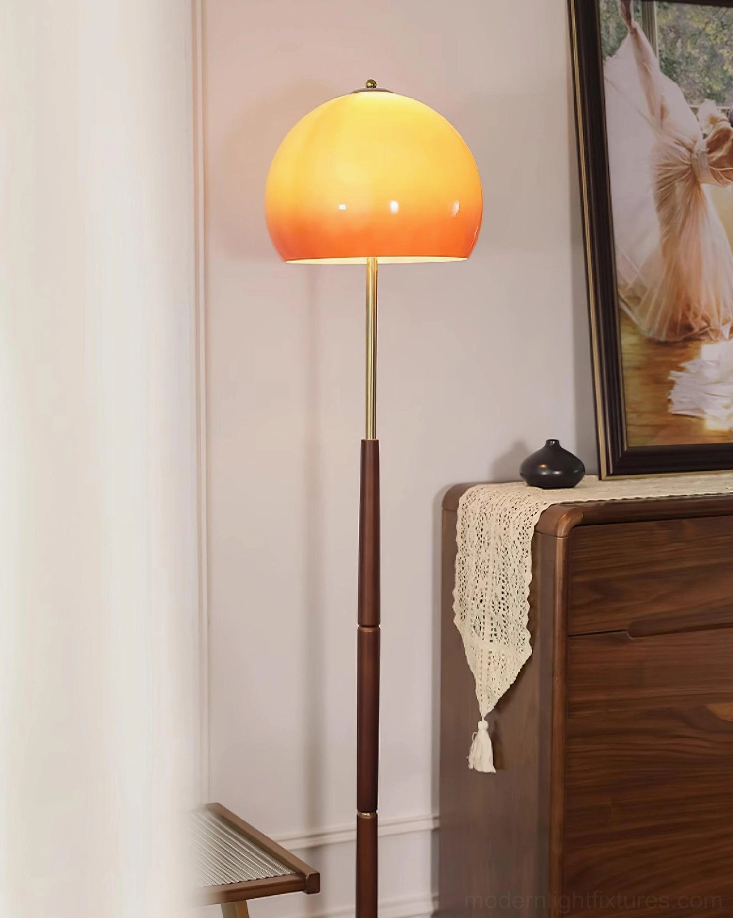 Mushroom floor lamp close-up showing warm glow caramel glass shade and wood pole near home decor
