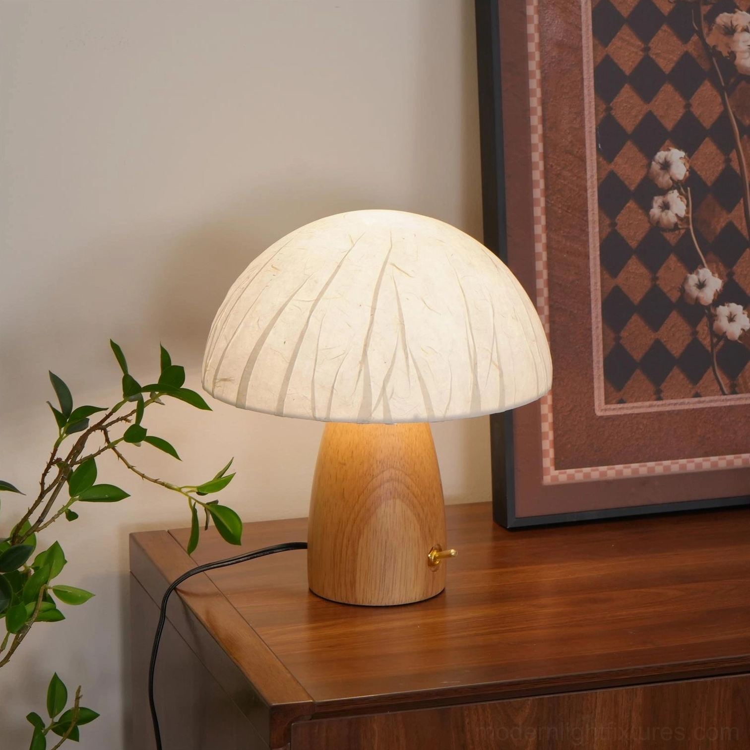 Contemporary table lamp with light wood base and off-white pleated shade in styled interior