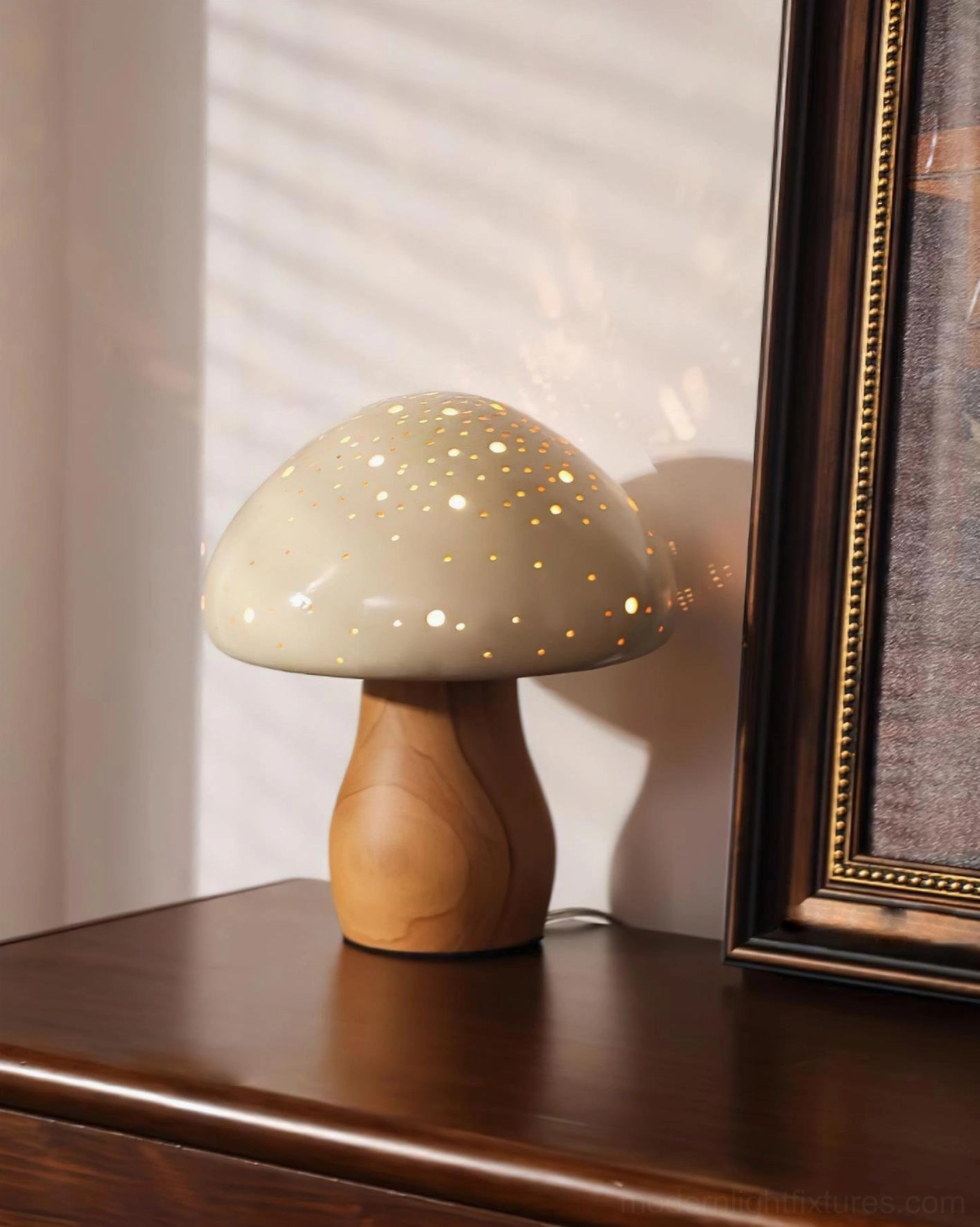 Mushroom table lamp with light tan perforated shade and light wood base creating warm ambient light