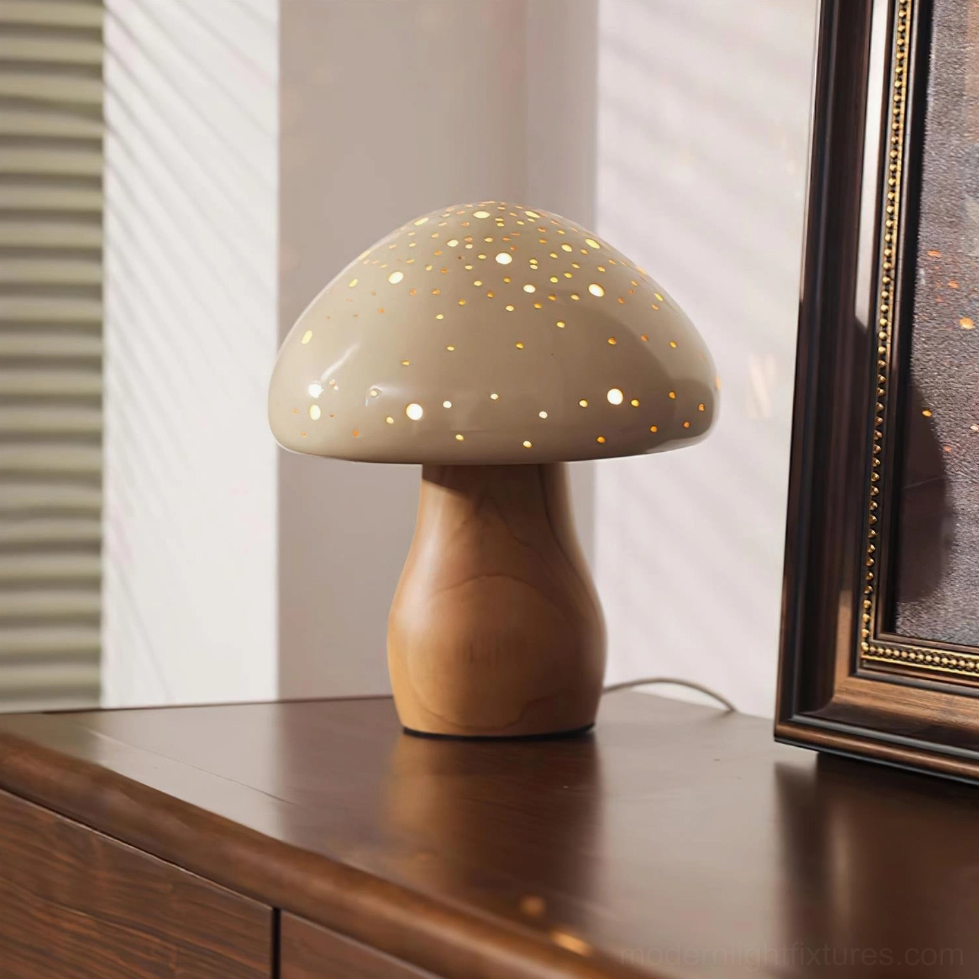 Warm glowing mushroom table lamp on nightstand with taupe perforated cap and natural wood stem