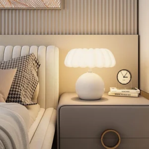 Modern mushroom lamp styled on bedroom nightstand with wall art and decorative throw pillow - contemporary interior design
